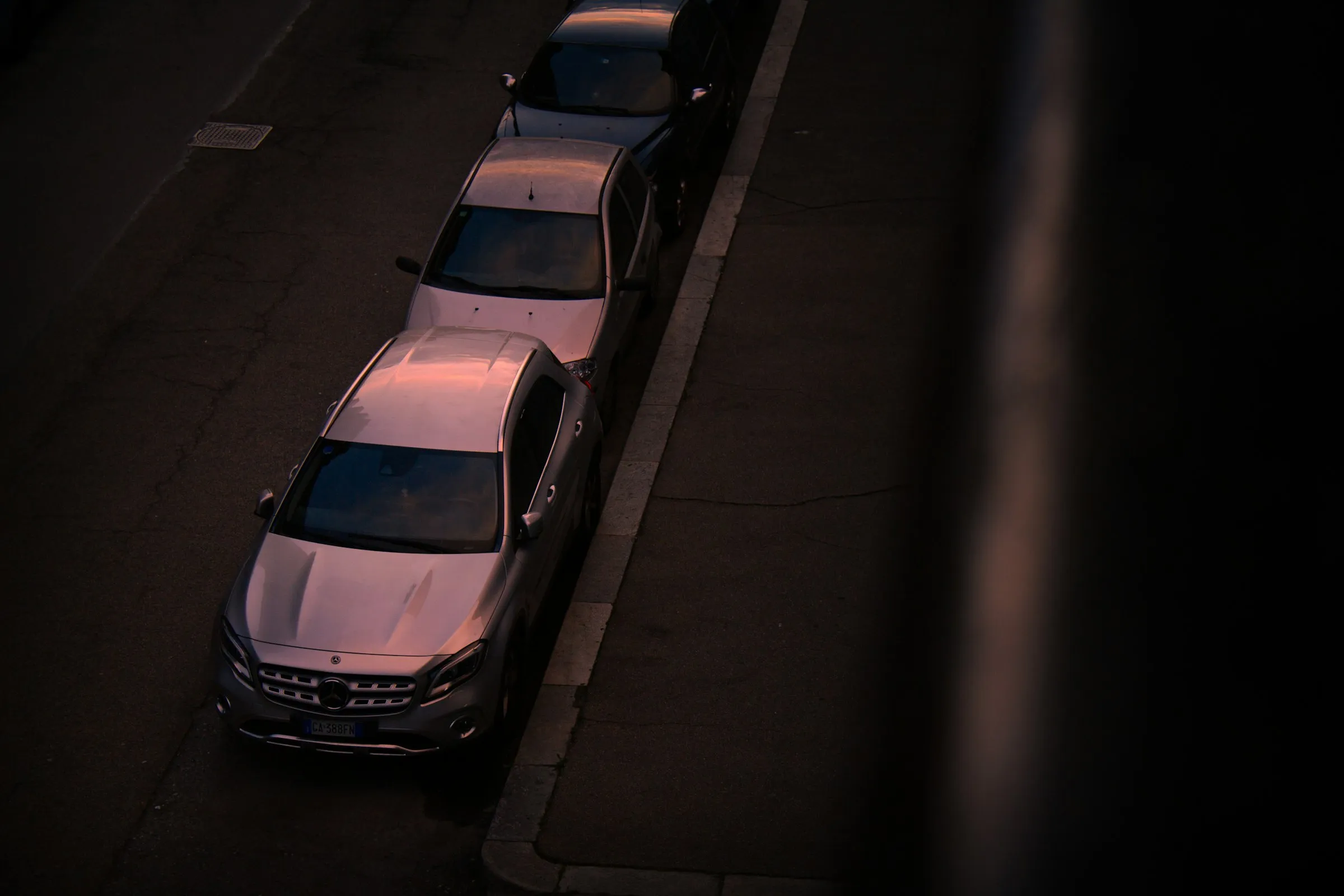 Fila de vehículos estacionados de noche