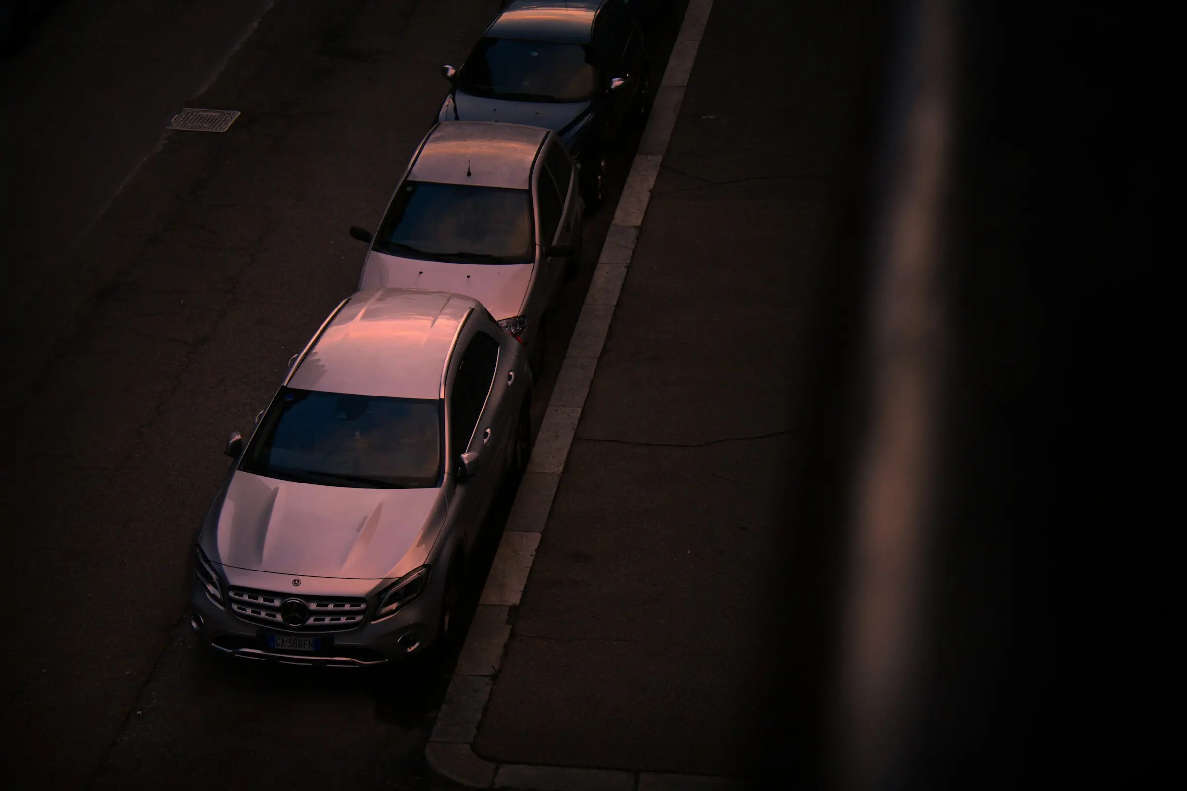 Fila de vehículos estacionados de noche