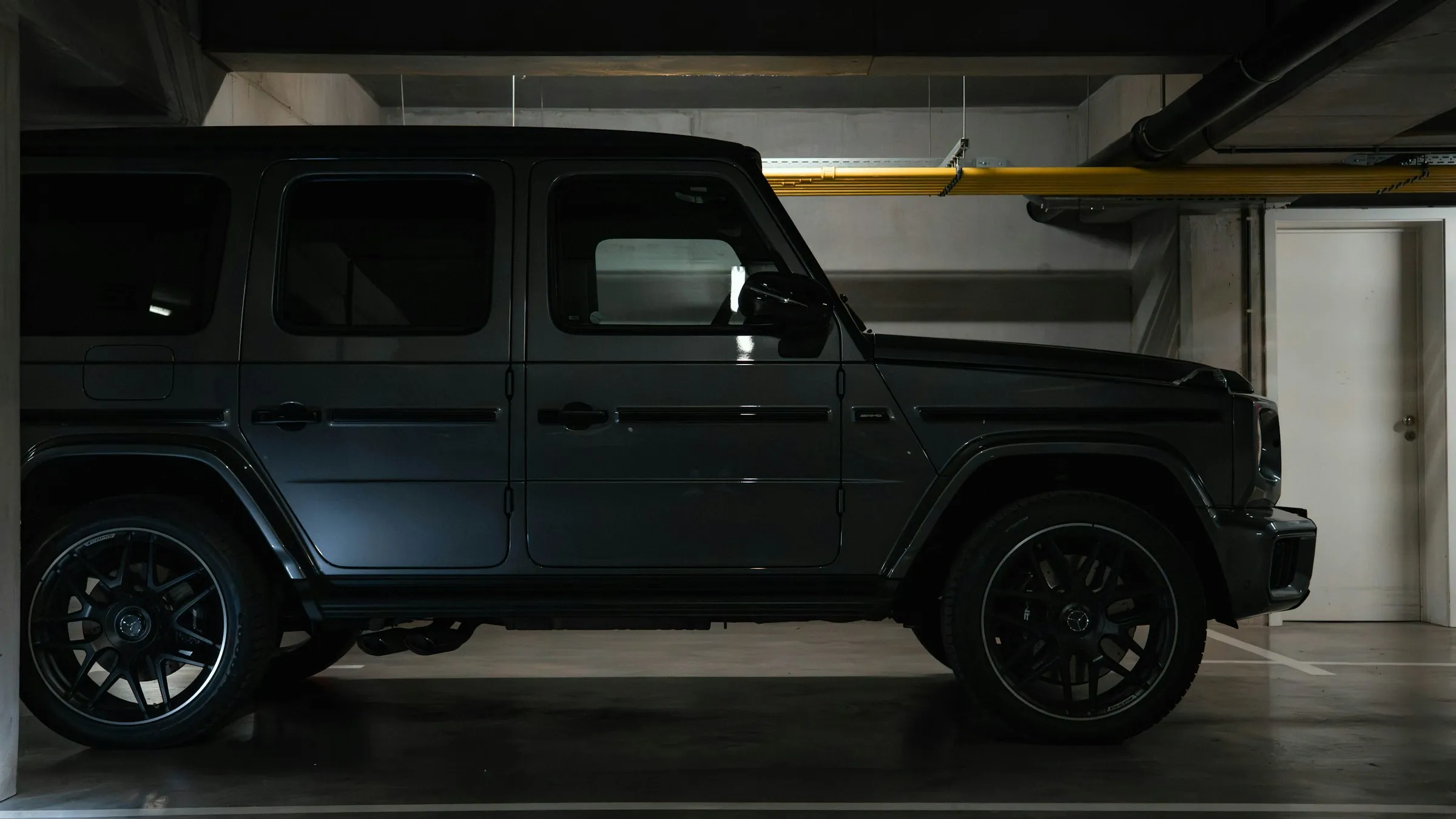 SUV oscuro estacionado en un taller con luz tenue